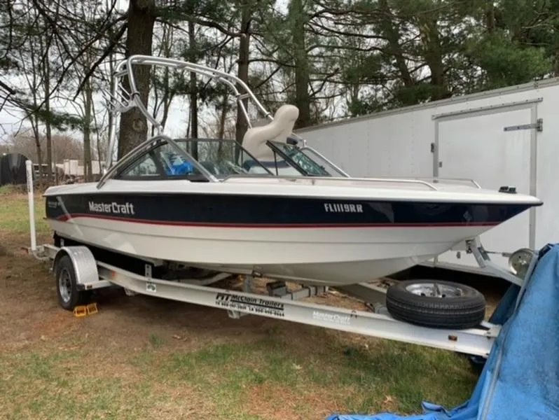 Slide: The Image of 1996 MasterCraft Prostar 205 boat on a trailer in a wooded area. - 4