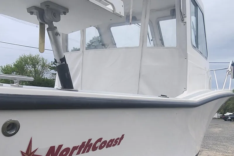 Slide: The Image of 2019 NorthCoast 215 Cabin boat with white exterior and red logo. - 17