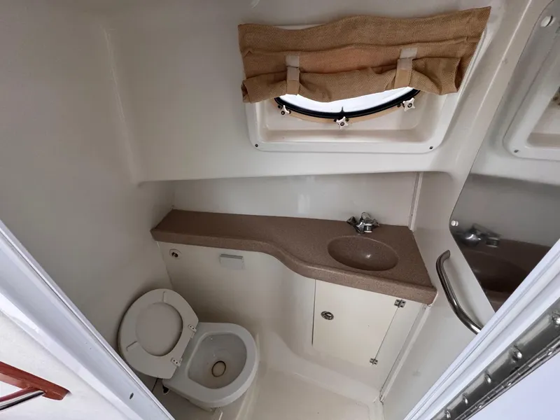 Slide: The Image of 2006 Pro-Line 32 Express boat bathroom with sink, toilet, and window. - 19