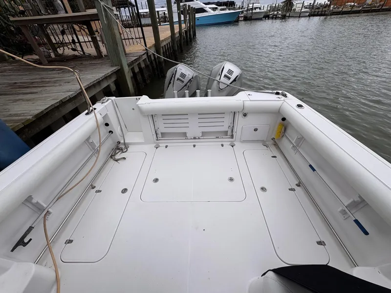 Slide: The Image of 2006 Pro-Line 32 Express boat deck with twin outboard motors at dock. - 5