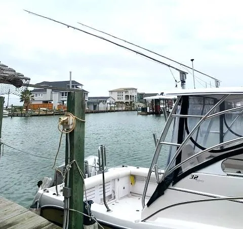 Slide: The Image of 2006 Pro-Line 32 Express boat docked in a marina with waterfront homes. - 6