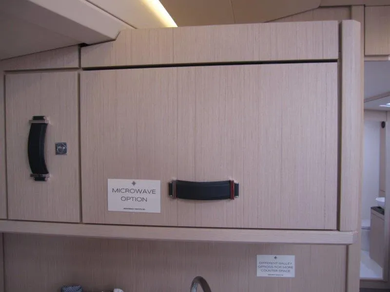 Slide: The Image of Jeanneau 60 2024 yacht interior cabinetry with microwave option. - 18
