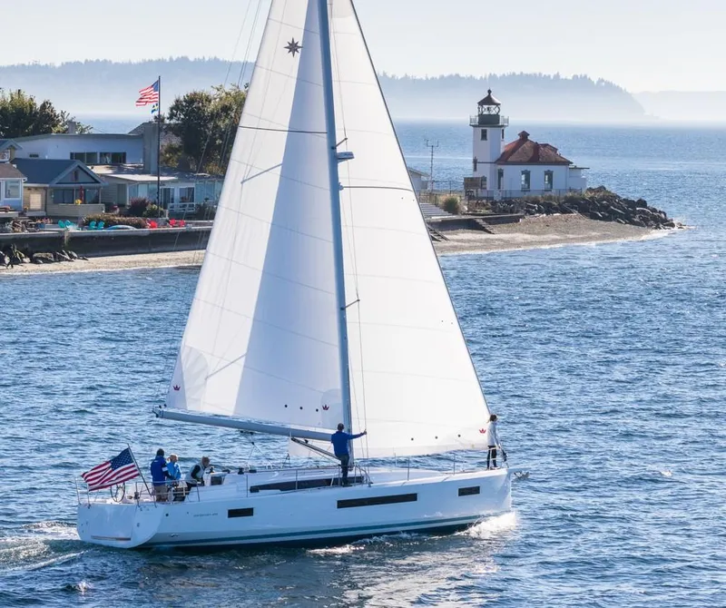 The Image of 2024 Jeanneau Sun Odyssey 490 sailing near a coastal lighthouse. - 0