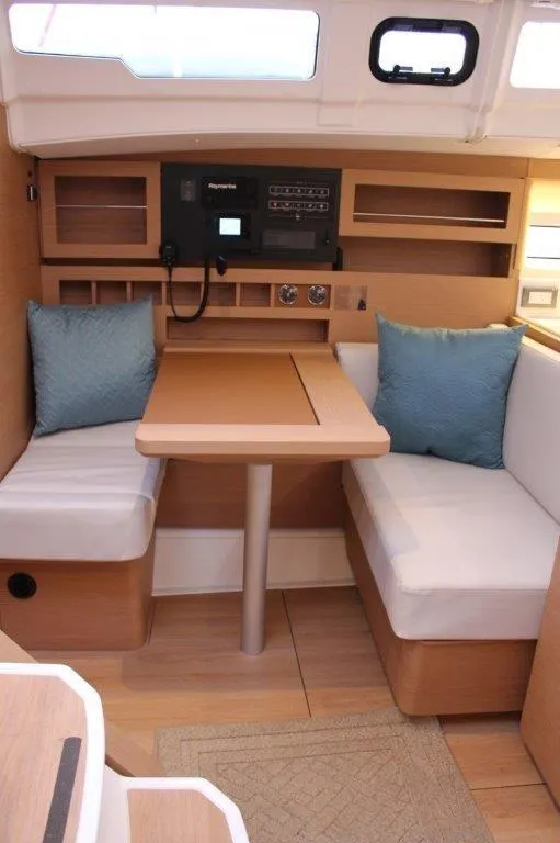 Slide: The Image of 2024 Jeanneau Sun Odyssey 490 interior with dining area and navigation station. - 26