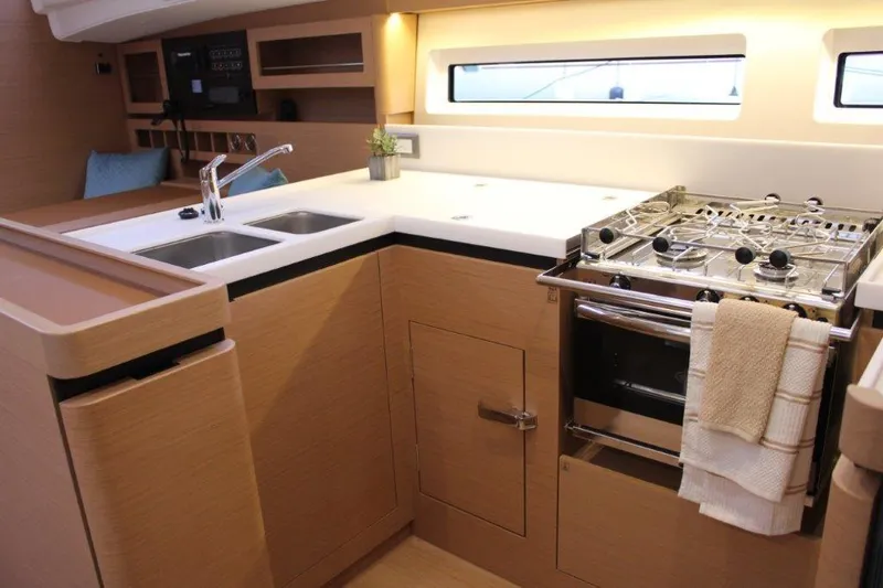Slide: The Image of Modern kitchen in 2024 Jeanneau Sun Odyssey 490 yacht with stove, sink, and ample counter space. - 35