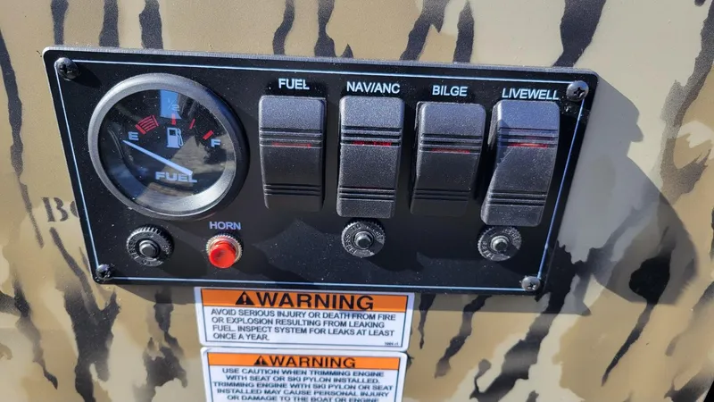 Slide: The Image of Control panel of 2025 Smoker Craft Sportsman 1866 tiller, camo, with fuel gauge and switches. - 9