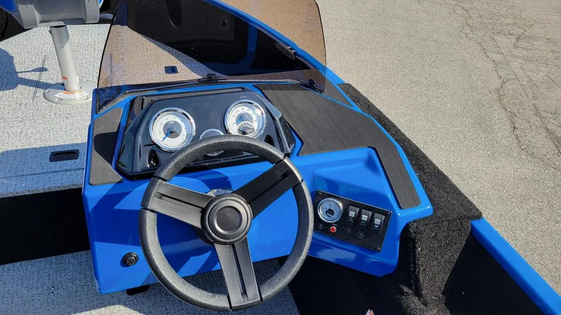 Slide: The Image of 2025 Smoker Craft Lazer 161 side console, blue dashboard with steering wheel and gauges. - 13
