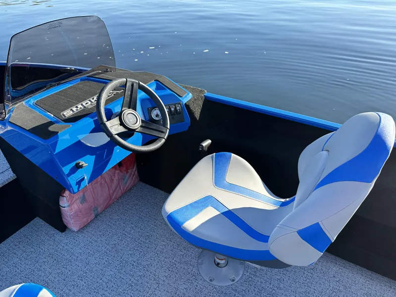 Slide: The Image of 2025 Smoker Craft Lazer 161 side console boat interior with blue and gray seating. - 19
