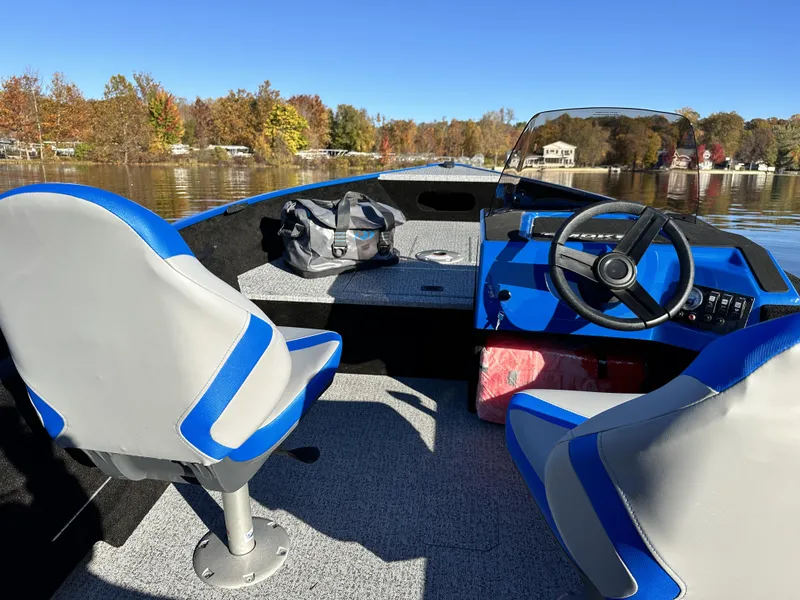Slide: The Image of 2025 Smoker Craft Lazer 161 side console boat interior with blue and gray seating. - 20