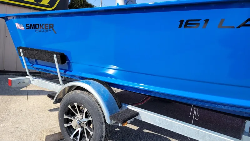 Slide: The Image of 2025 Smoker Craft Lazer 161 side console boat on trailer, vibrant blue finish. - 3