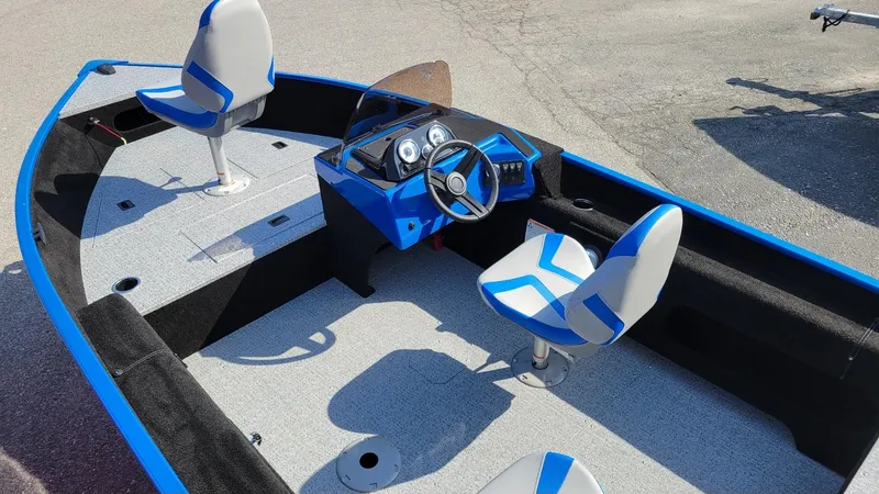 Slide: The Image of 2025 Smoker Craft Lazer 161 side console boat interior with blue accents and seating. - 4