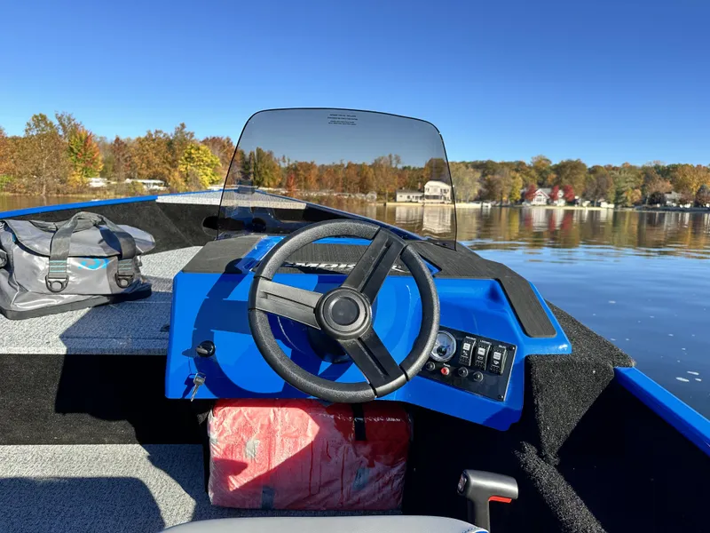 Slide: The Image of 2025 Smoker Craft Lazer 161 side console boat on a calm lake. - 8