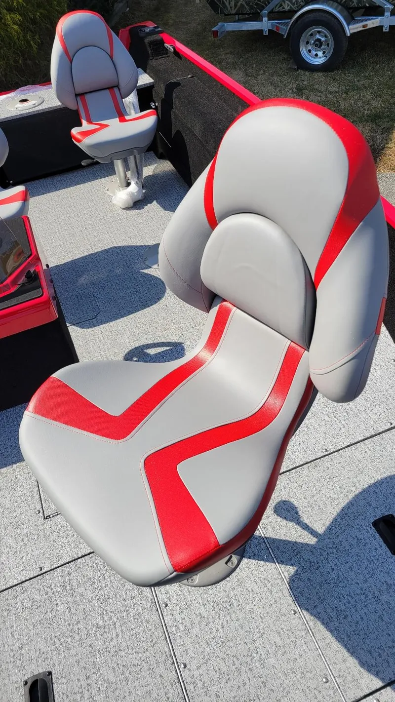 Slide: The Image of 2025 Smoker Craft Lazer 161 side console boat seat with red and gray design. - 11