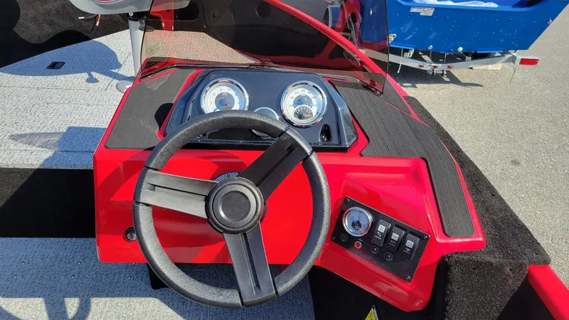Slide: The Image of 2025 Smoker Craft Lazer 161 side console, red dashboard with steering wheel and gauges. - 12