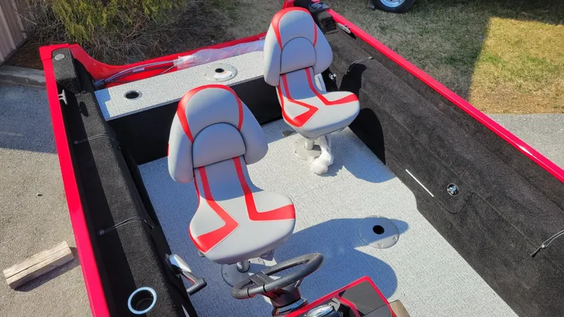 Slide: The Image of 2025 Smoker Craft Lazer 161 side console boat interior with red and gray seating. - 9