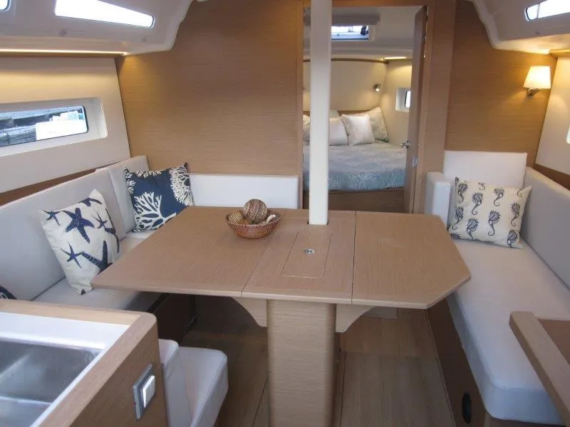 Slide: The Image of 2024 Jeanneau 380 yacht interior with dining area, cozy seating, and bedroom. - 21