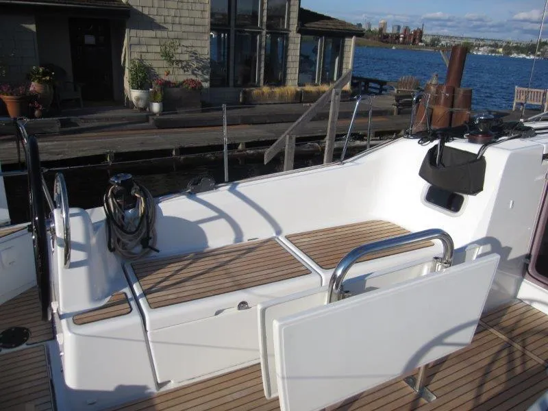 Slide: The Image of 2024 Jeanneau 380 sailboat cockpit with teak flooring, docked by waterfront. - 35