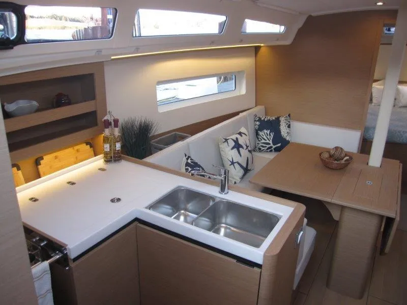 Slide: The Image of Modern interior of 2024 Jeanneau 380 sailboat with kitchen and dining area. - 4