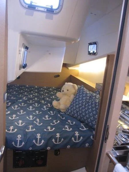 Slide: The Image of Cozy cabin interior of 2024 Jeanneau 380 sailboat with nautical-themed bedding. - 8