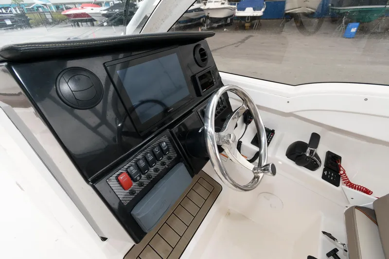 Slide: The Image of 2021 Cutwater C-24 DC boat dashboard with steering wheel and control panel. - 13