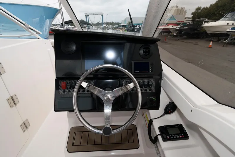 Slide: The Image of 2021 Cutwater C-24 DC boat helm with steering wheel and control panel. - 14