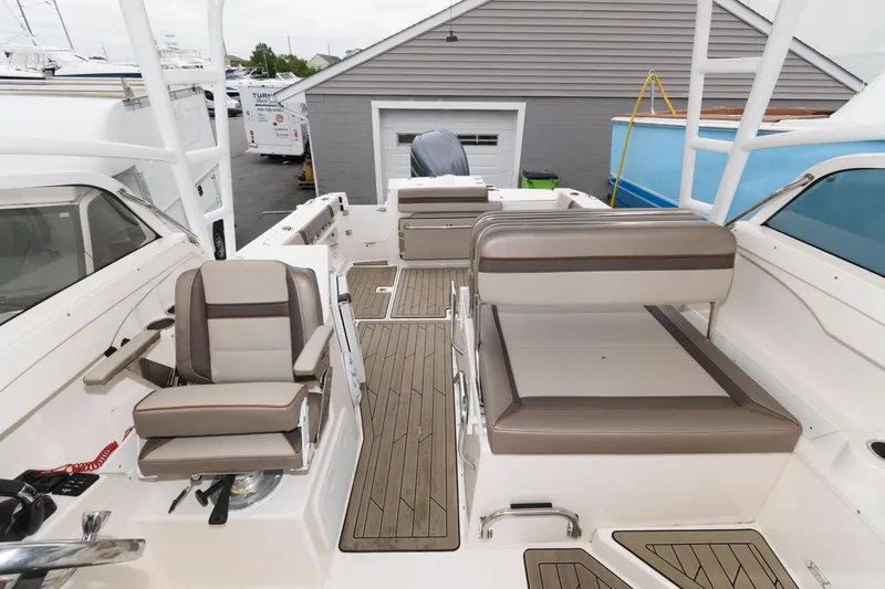 Slide: The Image of 2021 Cutwater C-24 DC boat interior with cushioned seating and wood-style flooring. - 7