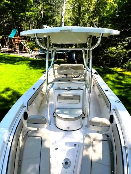 Slide: The Image of 2022 Sea Chaser 22 HFC boat with T-top, parked on grass, surrounded by trees. - 3