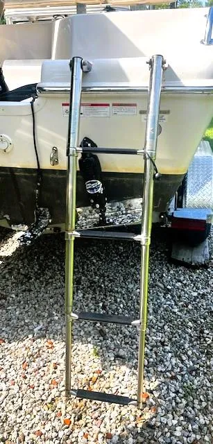 Slide: The Image of 2022 Sea Chaser 22 HFC boat with a metal boarding ladder on gravel. - 39