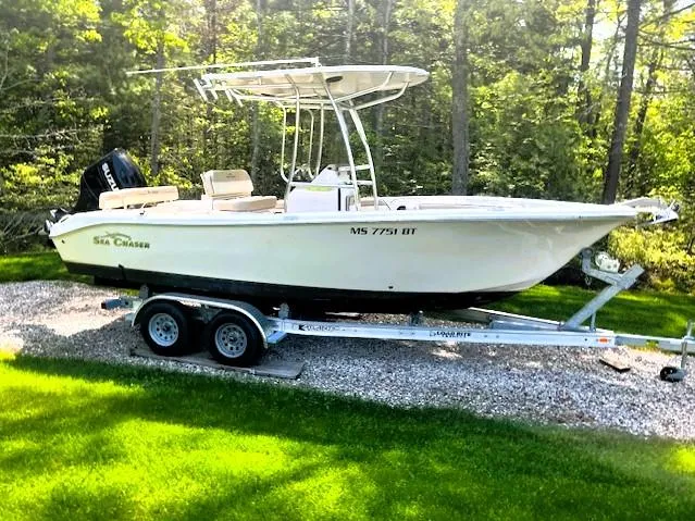 Slide: The Image of 2022 Sea Chaser 22 HFC boat on trailer, parked on grass with forest background. - 40