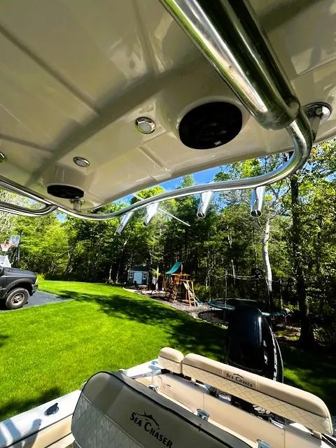 Slide: The Image of 2022 Sea Chaser 22 HFC boat interior with rod holders, lush green yard in background. - 6