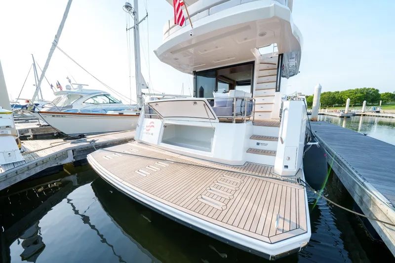 Slide: The Image of Luxury Sirena 48 yacht, 2024 model, docked at marina with spacious teak swim platform. - 10