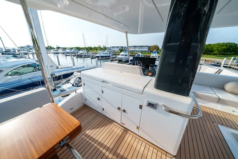 Slide: The Image of Sirena 48 yacht 2024 model, spacious deck with seating and marina view. - 12