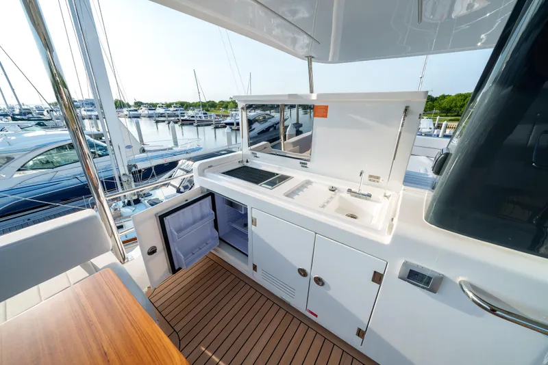 Slide: The Image of Outdoor kitchen area on the 2024 Sirena 48 yacht, featuring a sink, grill, and storage. - 13