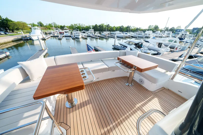 Slide: The Image of Luxury Sirena 48 yacht 2024 model, spacious deck with wooden tables, docked at marina. - 14