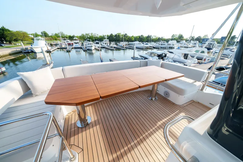 Slide: The Image of Luxury Sirena 48 yacht 2024 model, spacious deck with wooden table, marina view. - 15
