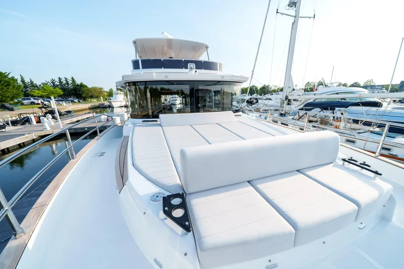 Slide: The Image of 2024 Sirena 48 yacht with spacious deck and luxurious seating at a marina. - 23