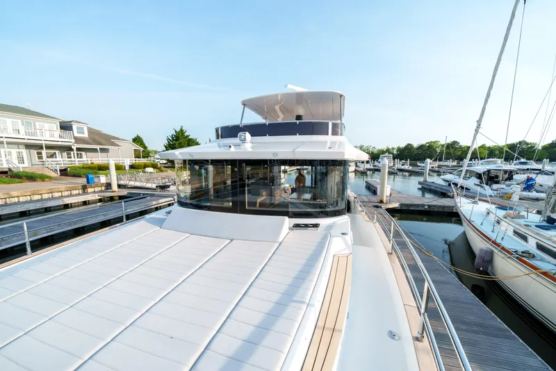 Slide: The Image of 2024 Sirena 48 yacht docked at a marina, showcasing its sleek design and spacious deck. - 27