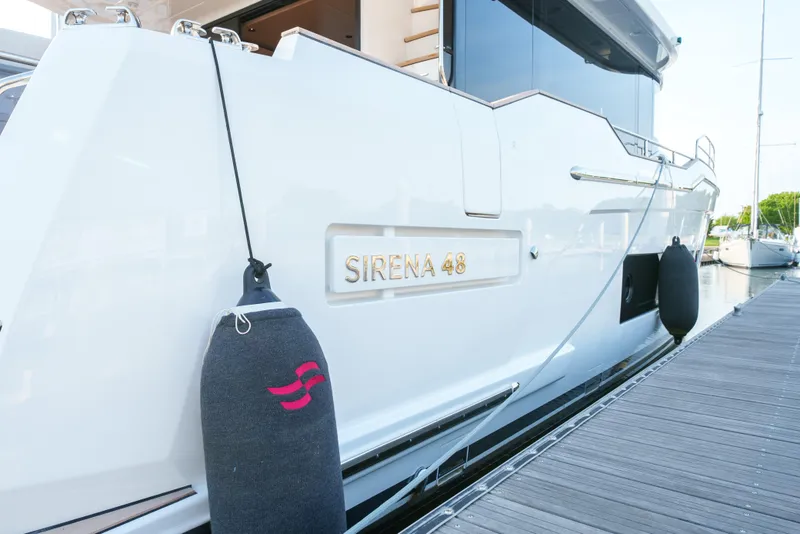 Slide: The Image of 2024 Sirena 48 yacht docked, showcasing sleek white exterior and branding. - 4