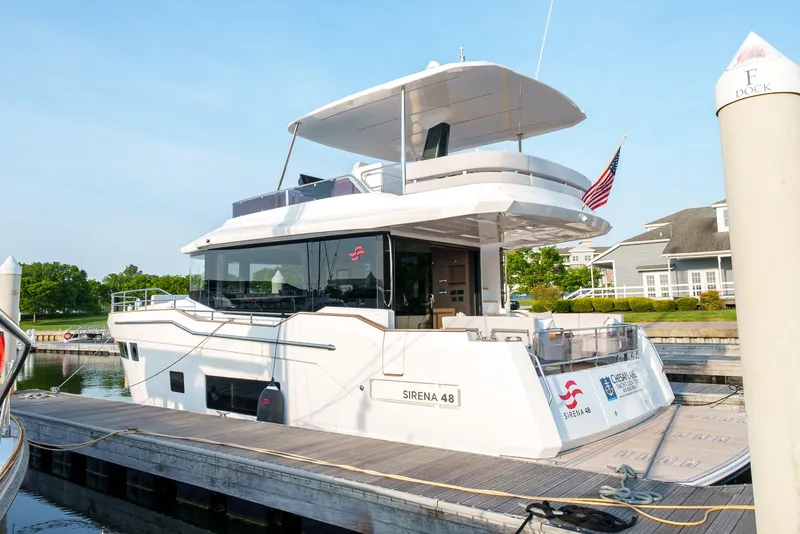 Slide: The Image of 2024 Sirena 48 yacht docked at a marina with an American flag. - 7