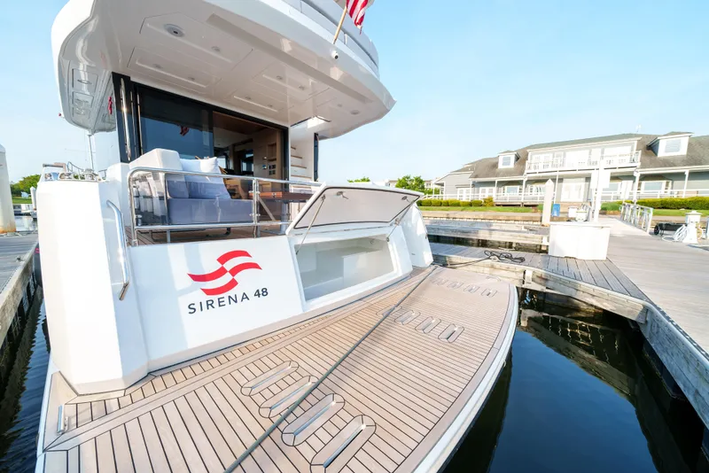 Slide: The Image of 2024 Sirena 48 yacht docked, showcasing spacious deck and modern design. - 9