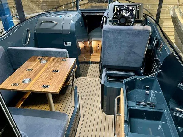 Slide: The Image of 2024 XO Boats EXPLR 10S interior with seating, table, and helm station. - 1