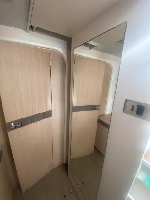 Slide: The Image of Interior cabin of a 2017 Bali 4.0 catamaran with bed and storage shelves. - 13
