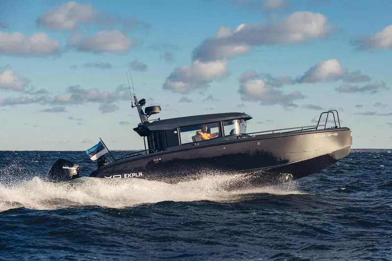 Slide: The Image of 2024 XO Boats EXPLR 10S cruising on open water under a partly cloudy sky. - 14