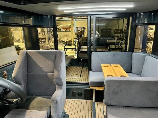 Slide: The Image of Interior of 2024 XO Boats EXPLR 10S with grey seating and wooden table. - 2