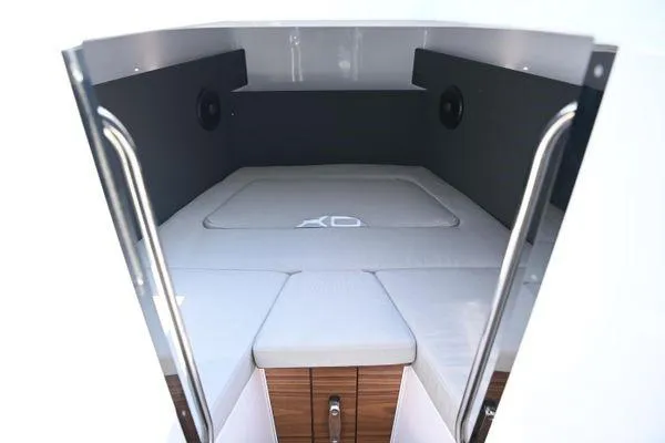 Slide: The Image of 2024 XO Boats EXPLR 10S cabin interior with cushioned seating and storage. - 6