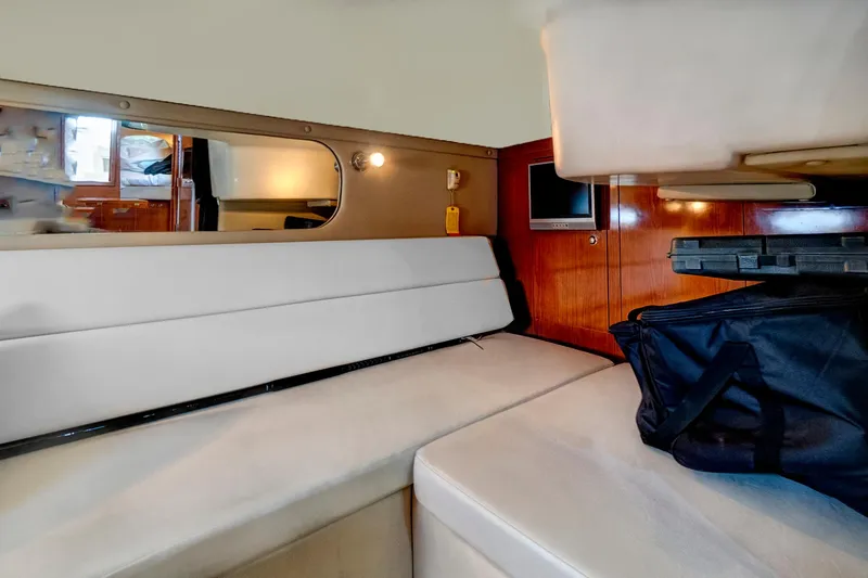 Slide: The Image of Interior cabin of 2006 Regal 3560 Commodore yacht with white seating and wooden paneling. - 22