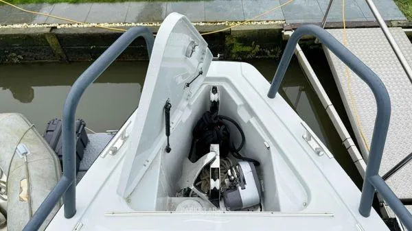 Slide: The Image of 2024 XO Boats DFNDR 9 storage compartment with open hatch. - 15