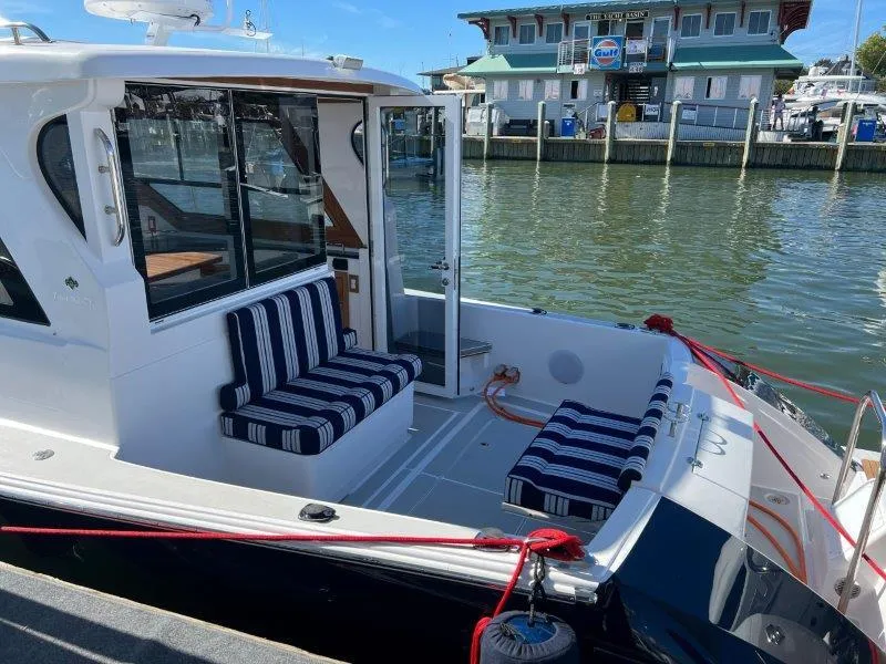 Slide: The Image of 2024 True North 34 boat with striped seating docked at a marina. - 12