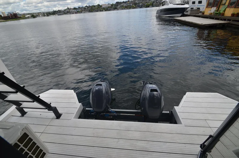 Slide: The Image of La Mare Modern 11 (2024) houseboat with twin outboard motors on a serene lake. - 31