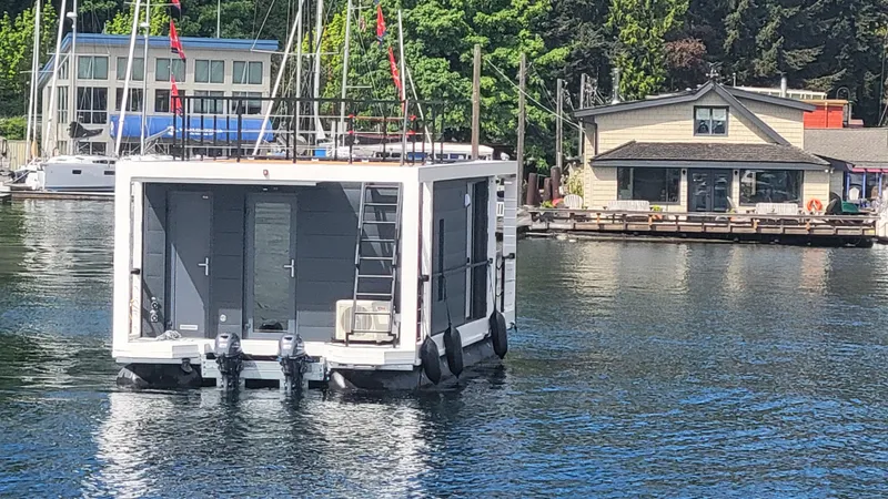Slide: The Image of Modern 2024 La Mare houseboat Modern 11 on a serene waterfront with docked boats and houses. - 41